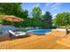 Idyllic backyard with wooden deck, patio umbrella, hot tub and pool in sunny landscaped fenced yard at 4224 River Rd, Columbus, IN 47203