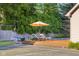 Picturesque backyard with lounging chairs, a patio umbrella, landscaping, and tennis court adds relaxation space at 4224 River Rd, Columbus, IN 47203