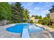 A well-kept fenced-in pool area with a diving board, stairs, and beautiful landscaping offers peaceful retreat at 4224 River Rd, Columbus, IN 47203