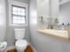 Charming bathroom featuring a white toilet, a sink with brushed nickel hardware and light gray walls at 4224 River Rd, Columbus, IN 47203