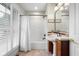 Bright bathroom featuring a pedestal sink, walk-in shower, and white window shutters at 4224 River Rd, Columbus, IN 47203