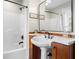 Bathroom with pedestal sink, dark bronze faucet, and walk-in shower and tub at 4224 River Rd, Columbus, IN 47203
