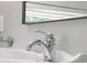 Close-up of a chrome bathroom faucet over a white sink with a large mirror behind it at 4224 River Rd, Columbus, IN 47203
