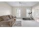 Bright bonus room with large windows, neutral walls and carpet, plus a treadmill and sofa at 4224 River Rd, Columbus, IN 47203