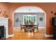 Bright dining room featuring hardwood floors, an arched entrance, and large windows at 4224 River Rd, Columbus, IN 47203