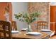 Dining table with place settings and a vase of flowers, with a brick accent wall at 4224 River Rd, Columbus, IN 47203