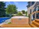 Backyard showcasing beautiful hot tub with a wooden deck and staircase, and a glimpse of the pool at 4224 River Rd, Columbus, IN 47203