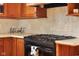 Kitchen stove top with tile backsplash and wood cabinets in a charming home at 4224 River Rd, Columbus, IN 47203