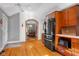 Open kitchen with stainless steel refrigerator and hardwood floors overlooks a dining area at 4224 River Rd, Columbus, IN 47203