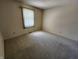 Empty bedroom with carpet flooring, neutral walls, and natural light from a window at 4501 N Wheeling Ave # 5E4, Muncie, IN 47304