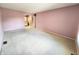 Large bedroom with neutral carpet, lilac walls, and view of a connecting bathroom at 4501 N Wheeling Ave # 5E4, Muncie, IN 47304