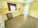 Bright kitchen featuring a stainless steel dishwasher, white cabinets, and tile floors at 4501 N Wheeling Ave # 5E4, Muncie, IN 47304