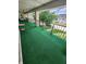 Spacious outdoor patio with green turf carpet and black railing at 4501 N Wheeling Ave # 5E4, Muncie, IN 47304