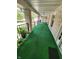 Spacious outdoor patio with green turf carpet and black railing at 4501 N Wheeling Ave # 5E4, Muncie, IN 47304
