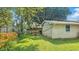 Backyard with mature lawn, detached garages, and flower beds at 4708 Fletcher Ave, Indianapolis, IN 46203