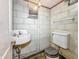Small basement bathroom featuring a toilet, sink, mirror and wall-mounted lighting at 4708 Fletcher Ave, Indianapolis, IN 46203