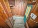 Stairwell leading to basement with wood paneling, white walls, and a teal door at 4708 Fletcher Ave, Indianapolis, IN 46203