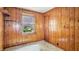 This is a view of a wood paneled bedroom with a window and closet at 4708 Fletcher Ave, Indianapolis, IN 46203