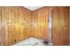 Bedroom featuring paneled walls, worn floors, and a door on the right side at 4708 Fletcher Ave, Indianapolis, IN 46203