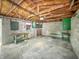 Unfinished garage with concrete block walls, high wood truss ceiling, and a concrete floor at 4708 Fletcher Ave, Indianapolis, IN 46203
