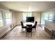 Open dining area with a round table, seating for four, a decorative rug, and abundant natural light from large windows at 514 E 2Nd St, Sheridan, IN 46069