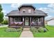 Charming two-story home with a covered front porch decorated with patriotic bunting and well-maintained landscaping at 514 E 2Nd St, Sheridan, IN 46069