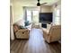 Inviting living area with a plush sofa, recliner, a ceiling fan, a modern TV stand, and abundant natural light at 514 E 2Nd St, Sheridan, IN 46069