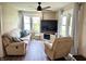 Comfortable living room featuring a plush sofa, recliner, a ceiling fan, a flat-screen TV, and ample natural light at 514 E 2Nd St, Sheridan, IN 46069