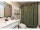 Neutral bathroom featuring a shower with a green curtain and vanity with a black faucet and ample counter space at 59 Millet Ct, Danville, IN 46122