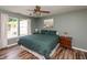 A green bedroom features a queen bed, a ceiling fan, and a large window at 59 Millet Ct, Danville, IN 46122