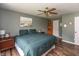 A green bedroom features a queen bed, ceiling fan, and an accent corner cabinet at 59 Millet Ct, Danville, IN 46122