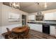 Eat-in kitchen featuring white cabinets, wood table, and modern lighting at 59 Millet Ct, Danville, IN 46122