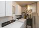 A compact laundry room features a washer, a dryer, and functional overhead cabinets at 59 Millet Ct, Danville, IN 46122