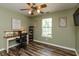 A home office with a desk, chair, and a view from the window, all illuminated by a ceiling fan at 59 Millet Ct, Danville, IN 46122