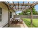 Covered patio with wooden table and benches, leading to a fenced backyard with grass at 59 Millet Ct, Danville, IN 46122