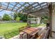Covered patio with a wooden table and bench, and a large backyard with a shed and grill at 59 Millet Ct, Danville, IN 46122