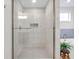 Elegant bathroom features a modern glass shower with white tile, complemented by a soaking tub in the background at 6137 Hardwick Dr, Whitestown, IN 46075
