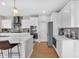 Modern kitchen with stainless steel appliances, white cabinetry, quartz countertops, and hardwood flooring at 6137 Hardwick Dr, Whitestown, IN 46075