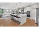 Open-concept kitchen boasts a large island with seating, stainless appliances, and seamless flow into the dining area at 6137 Hardwick Dr, Whitestown, IN 46075