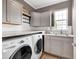 Well-equipped laundry room featuring sleek gray cabinetry, modern washer and dryer, and ample counter space for folding at 6137 Hardwick Dr, Whitestown, IN 46075