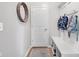 Well-lit mudroom features a convenient bench with storage, coat hooks, and a round mirror for added style at 6137 Hardwick Dr, Whitestown, IN 46075