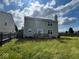 Back exterior of home with solar panels, a small deck, and a spacious yard at 7532 Gold Rush Ct, Camby, IN 46113