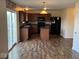 Spacious kitchen with wood cabinets, dark countertops, island, black appliances, and sliding glass door at 7532 Gold Rush Ct, Camby, IN 46113