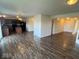 Open-concept living room showcasing wood floors, neutral walls, and view of kitchen and entryway at 7532 Gold Rush Ct, Camby, IN 46113