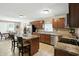Bright eat-in kitchen with tile floors, stainless appliances, island with barstools, and a dining table with seating at 8380 Kolven Dr, Avon, IN 46123