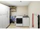 The bright laundry room includes a washer and dryer, built-in shelving and cabinets, and storage for supplies at 8380 Kolven Dr, Avon, IN 46123