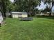A large backyard with lush green grass, a trampoline, and a storage shed at 105 Cottonwood Dr, Maxwell, IN 46154