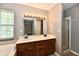Bathroom featuring a double sink vanity, bathtub, walk-in shower, and well-lit mirror at 10548 Magenta Dr, Noblesville, IN 46060