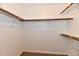 Walk-in closet with white walls, carpeted floor, and wooden rails for clothing and storage at 10548 Magenta Dr, Noblesville, IN 46060