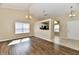 Open living room with hardwood floors, neutral paint, and a view into the kitchen at 10548 Magenta Dr, Noblesville, IN 46060